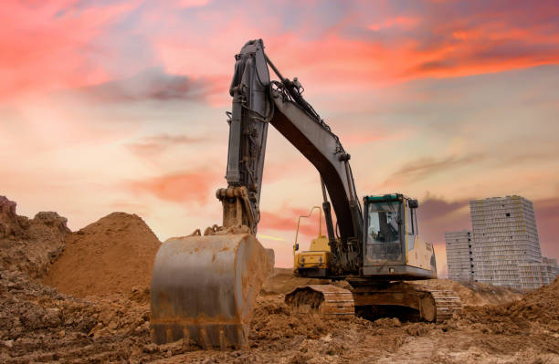 istock Track-type excavator during earthmoving at construction site. Backhoe digging the ground for the foundation and for laying sewer pipes district heating. Earth-moving heavy equipment 1867925767