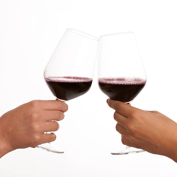istock Two glasses of red wine in hands isolated 186794268