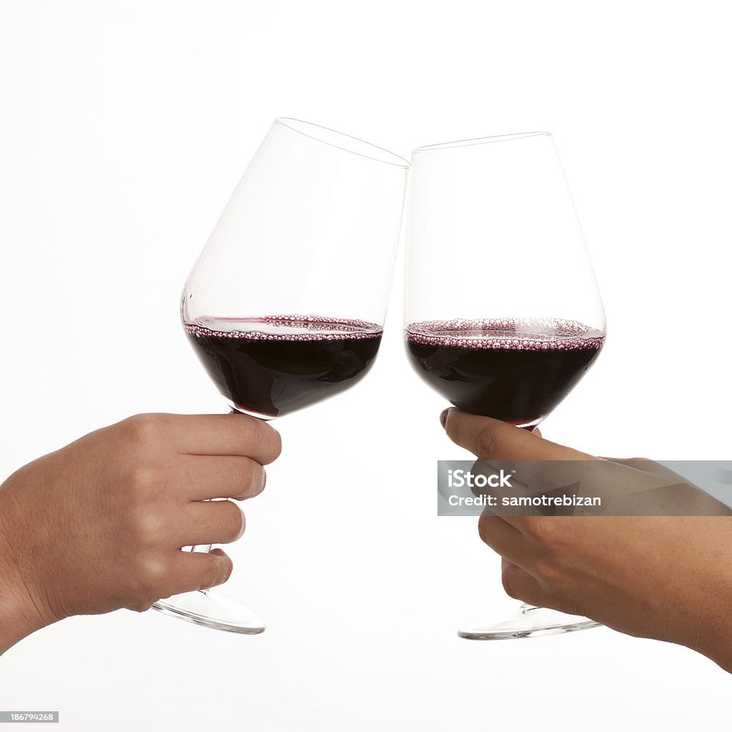 Two glasses of red wine in hands isolated Two glasses of red wine in hands making toast isolated over white background. Cut Out Stock Photo