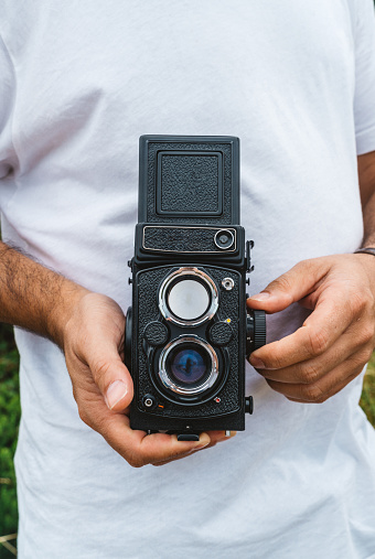 happy photographer in bow tie with a vintage twin-lens reflex camera