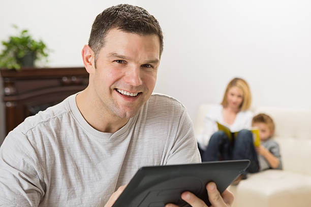 istock Father using digital tablet device at home with family 186795823