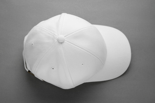 Stylish white baseball cap on grey background, top view