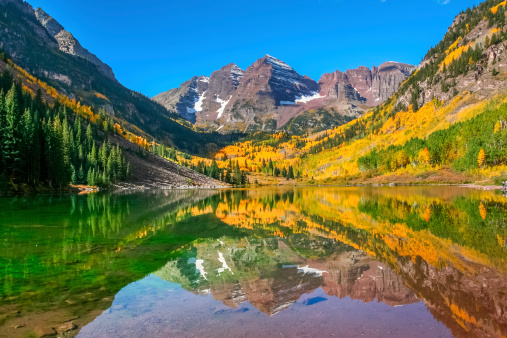 Maroon Bells and Maroon Lake - autumn colors at sunrise, near Aspen, Colorado, in the Elk Mountains.