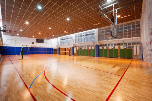 Brand new school gymnasium, with basketball backboards, set up for volleyball or basketball.