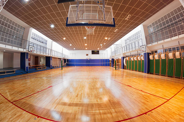 School gymnasium Brand new school gymnasium, with basketball backboards, set up for volleyball or basketball. school bleachers stock pictures, royalty-free photos & images