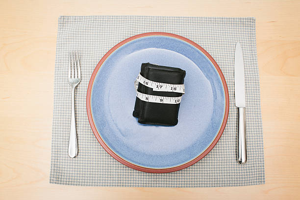 geld zur ernährung - healthy eating fork tape measure still life stock-fotos und bilder