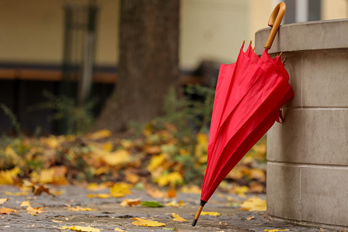 Autumn atmosphere. One red umbrella on city street, space for text