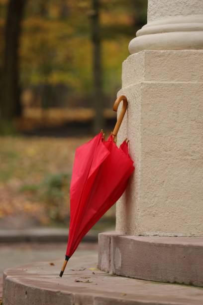istock Autumn atmosphere. One red umbrella in park 1867982485