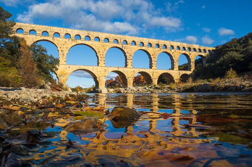 The Pont du Gard in autumn. Ancient Roman three-tiered aqueduct bridge. Built in the 1st century AD to carry water to the Roman colony of Nemausus (Nîmes).  Photography taken in Vers-Pont-du-Gard, Provence, southern France