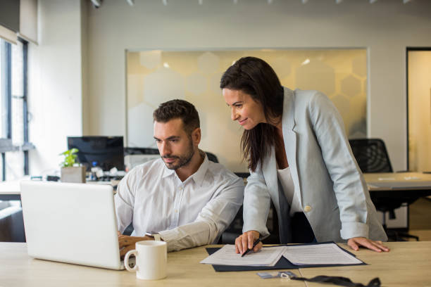 istock Businessman using laptop while showing project to colleague 1867986192