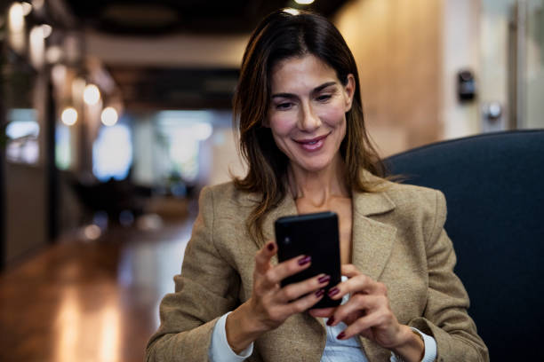 istock Businesswoman using smartphone while sitting on couch 1867987345