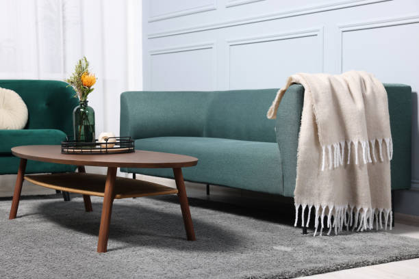 istock Comfortable sofa, blanket, table and armchair in living room 1867992054