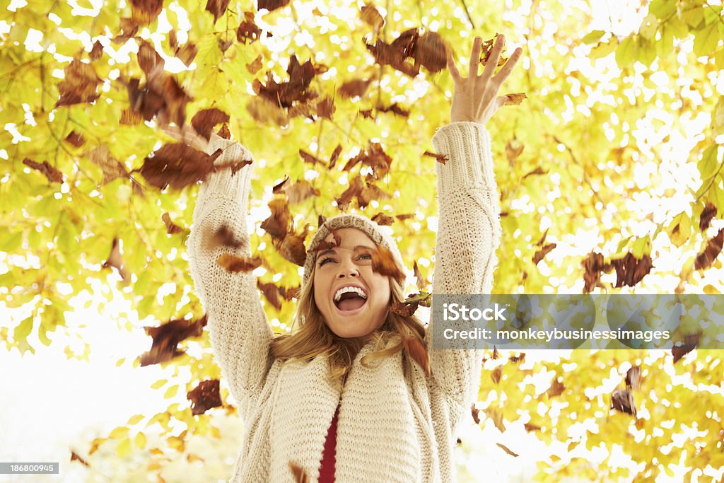 Mulher jogando outono folhas para o ar - Foto de stock de Folha royalty-free