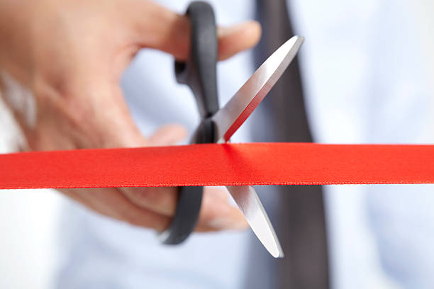 Cutting A Red Ribbon Man cutting a red ribbon. day 1 stock pictures, royalty-free photos & images
