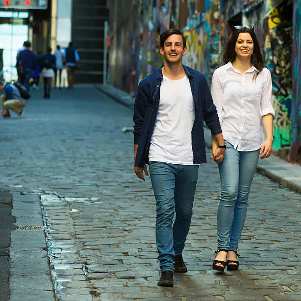 Young couple holding hands in a lane way