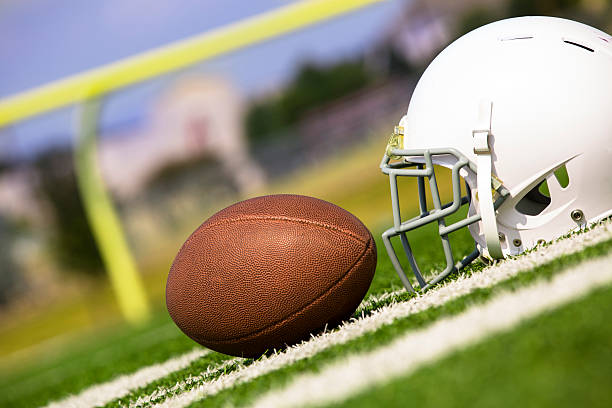 istock Sports:  Football and helmet on playing field. 186801550