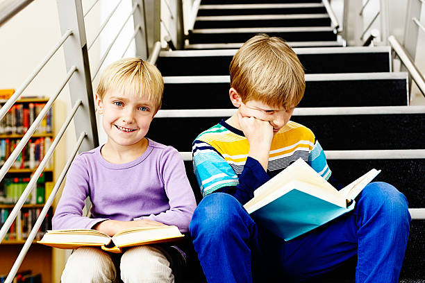 istock Blonde siblings enjoying time together in library 186803808