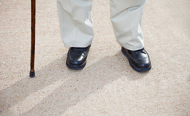istock senior man feet and cane standing on sidewalk 186804169