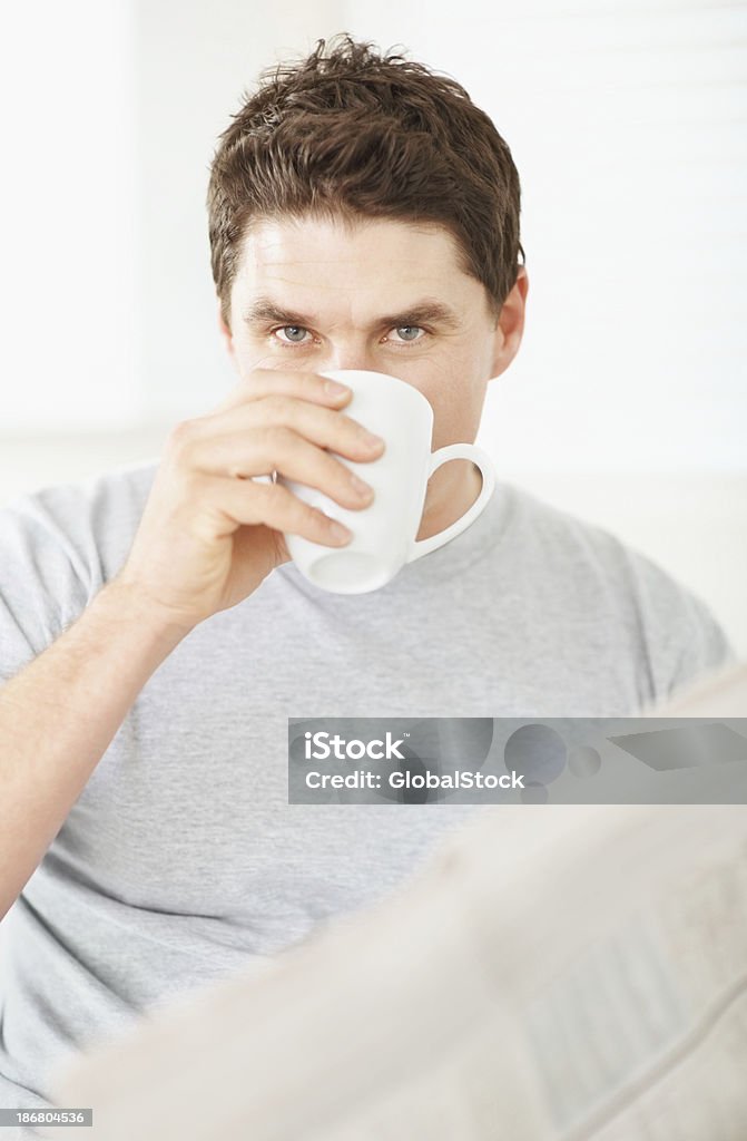 Człowiek pije kawę i trzymając gazetę - Zbiór zdjęć royalty-free (30-39 lat)