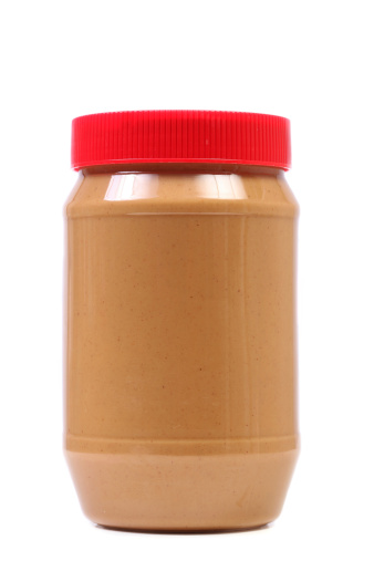 Jar of peanut butter isolated on white background.