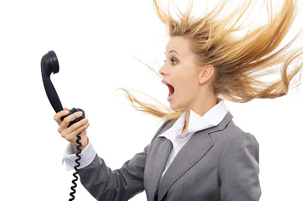 Surprised businesswoman with telephone. Isolated on white background.