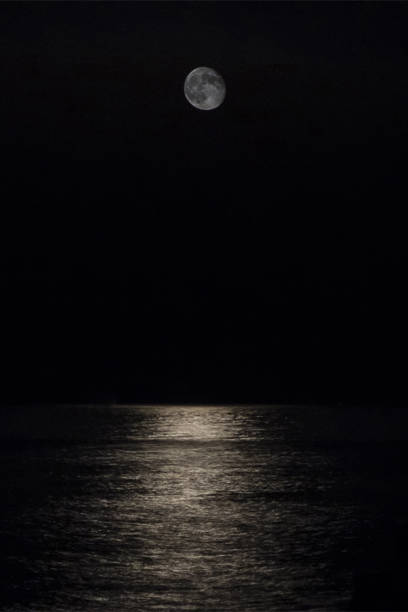 istock Full moon over a serene sea at night 1868057214