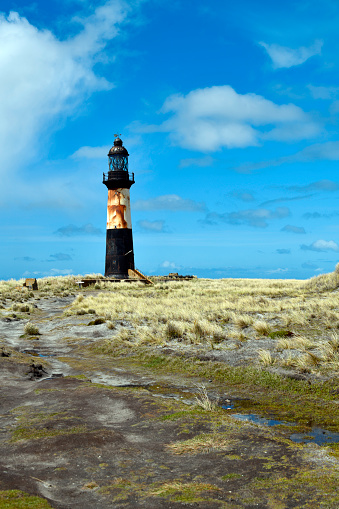 Cape Pembroke / Cabo San Felipe, East Falkland, Falkland Islands: Cape Pembroke lighthouse - metal tower completed in 1907 by Trinity House, using a light mounted on a clockwork stand, painted black with a broad white band - Cape Pembroke is the most easterly point of the Falkland Islands.