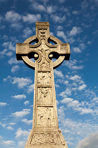 большой кельтский крест с голубое небо на заднем плане - celtic cross cross shape blue vertical стоковые фото и изображения