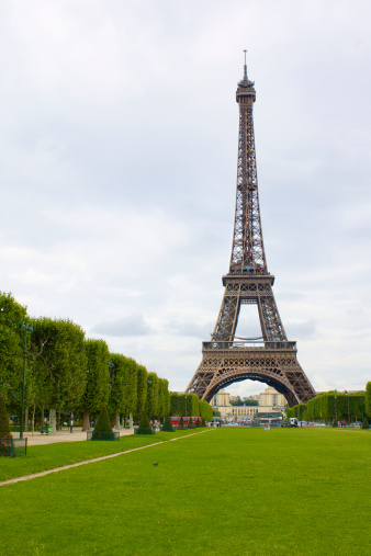 Eiffel tower from Champ de Mars over cloudy sky