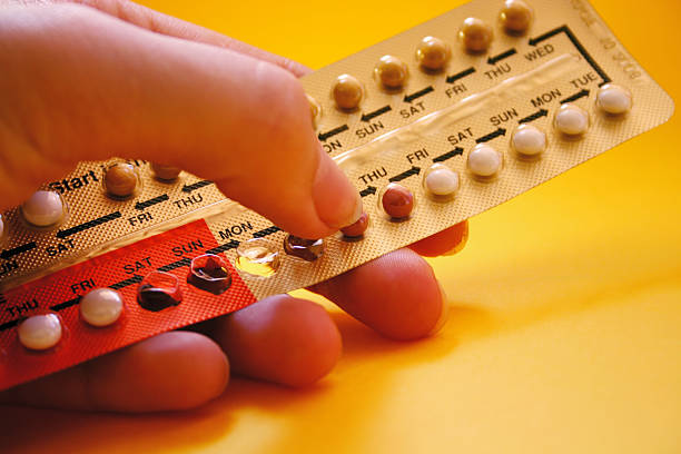 Close up of hand holding a pack of oral contraceptives stock photo