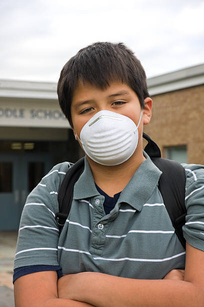 boy with mask on to protect against the flu stock photo