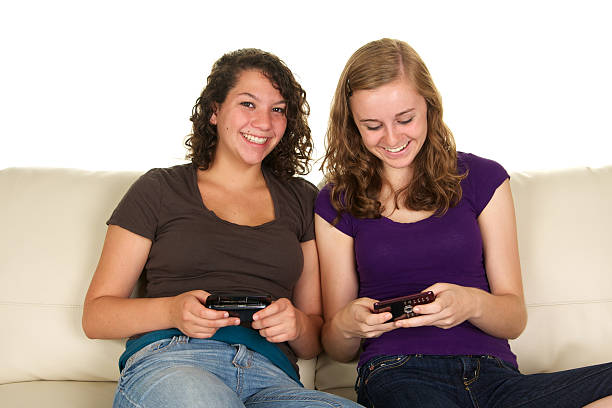 istock Teenage Girls Texting on a Sofa 186807246