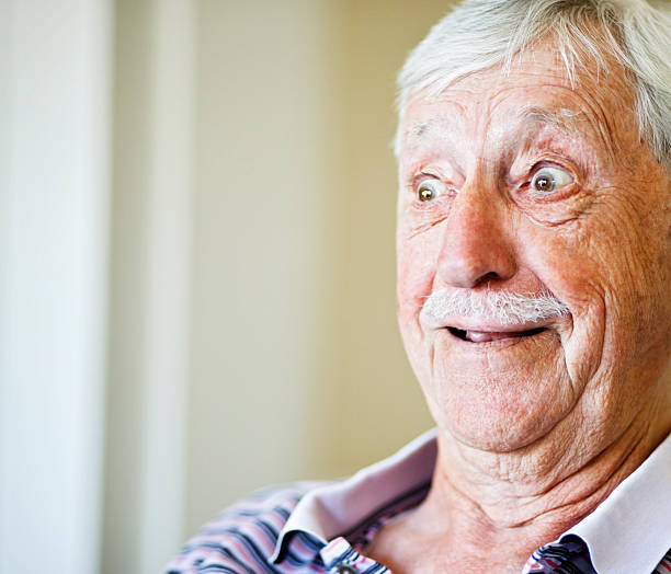 istock Wide eyed old man looks happily surprised 186807363
