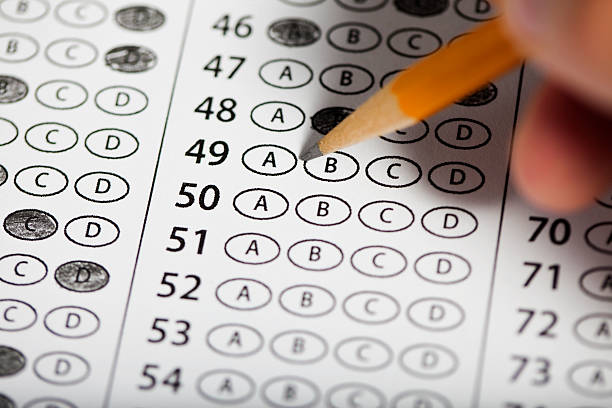 Exam Close of of hand filling out answers on a multiple choice exam. personality test stock pictures, royalty-free photos & images