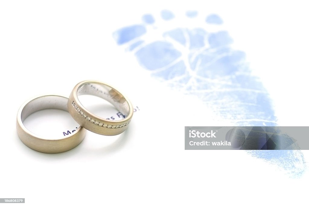 wedding rings and footstep - Hochzeitsringe und Fußabdruck wedding rings an baby footsteps on white background Anniversary Stock Photo