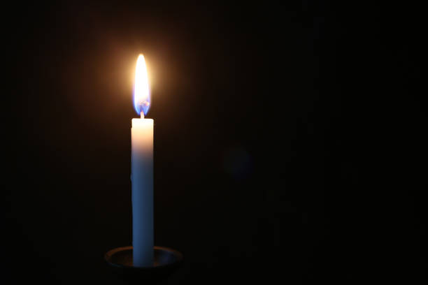 istock Candle and its light isolated on a black background. 1868084151