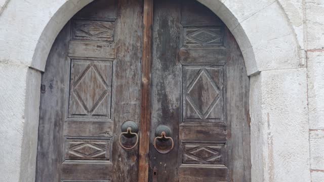 Close-up of closing old wooden door with metal handle in ancient