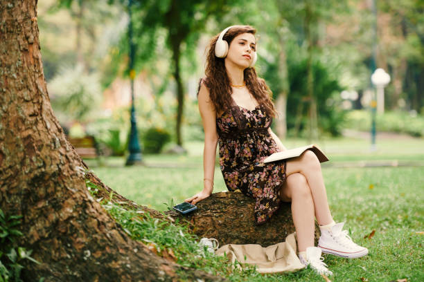 istock Pensive Young Woman Sitting under Tree 1868091841
