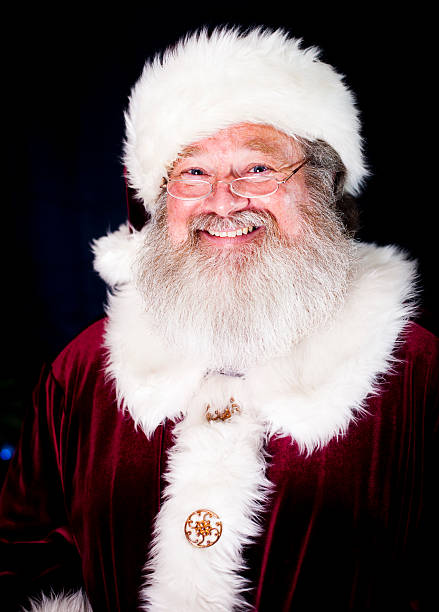 Portrait of a real Santa Claus Smiling on dark background. Room for copy space. Merry Christmas!