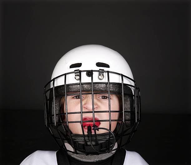 Youth Hockey Player A close up portrait of a young male hockey player wearing his helmut and mouth guard. There is plenty of copy space.Click on an mouthguard stock pictures, royalty-free photos & images