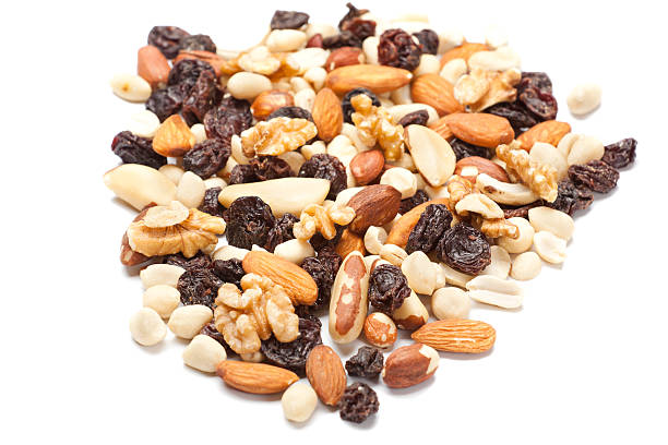 mixed snacks Heap of mixed nuts and dry fruits isolated on white background. dried fruit on white stock pictures, royalty-free photos & images