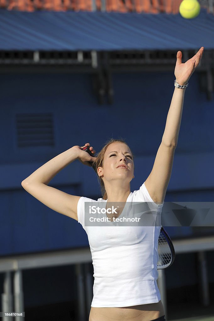 Giocatore di tennis femminile in servizio - Foto stock royalty-free di Abbigliamento da tennis