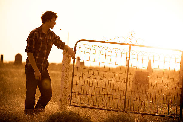 A young man in an overgrown country graveyard