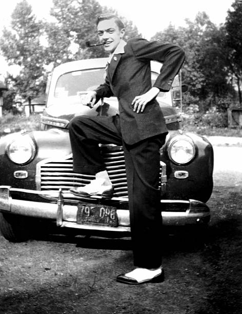 Vintage. Snazzy! Check out this big spender leaning on his car in a pin striped suit with a pipe in his mouth.Vintage - from the late 1930's. 1940s style stock pictures, royalty-free photos & images