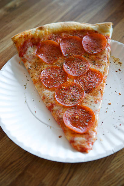 istock Greasy Slice of Pepperoni Pizza on Paper Plate 186810963
