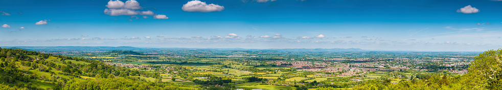 Deep blue summer skies over a vibrant green patchwork landscape of fields, pasture and suburban homes in this idyllic panoramic vista. ProPhoto RGB profile for maximum color fidelity and gamut.