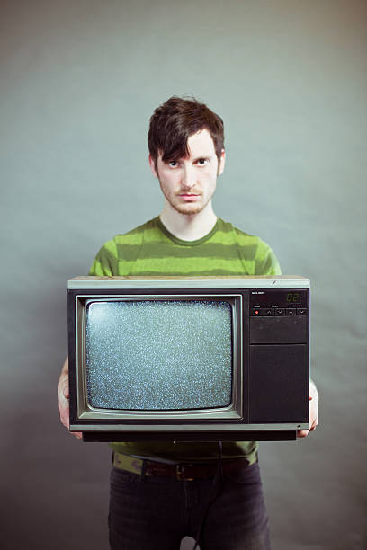 maussade jeune homme tenant statique télévision - copy space one person vertical 1970s style photos et images de collection