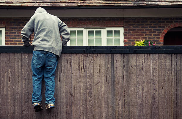 Boy in hoodie trespassing on private residential property stock photo
