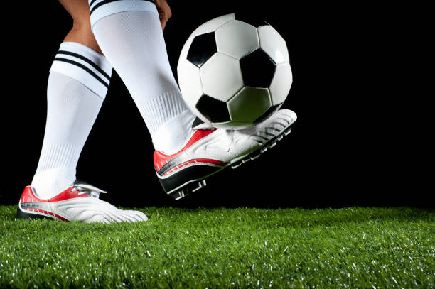 Man balancing a soccer ball Man balancing a soccer ball on one foot football boot stock pictures, royalty-free photos & images