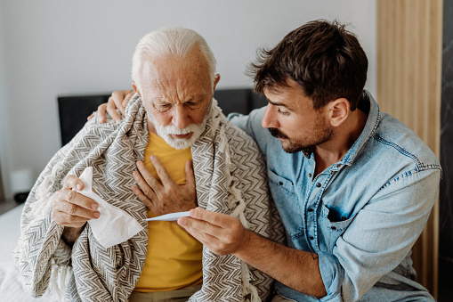 Son taking care of his father because of virus sypmtoms